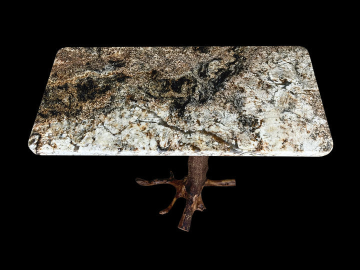 Top view of a magma gold granite top with a brown tree stump base against a black back drop.