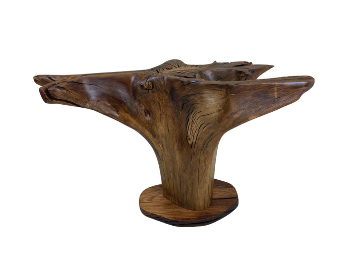 An oak tree stump dining table with out a glass top against a solid white background.