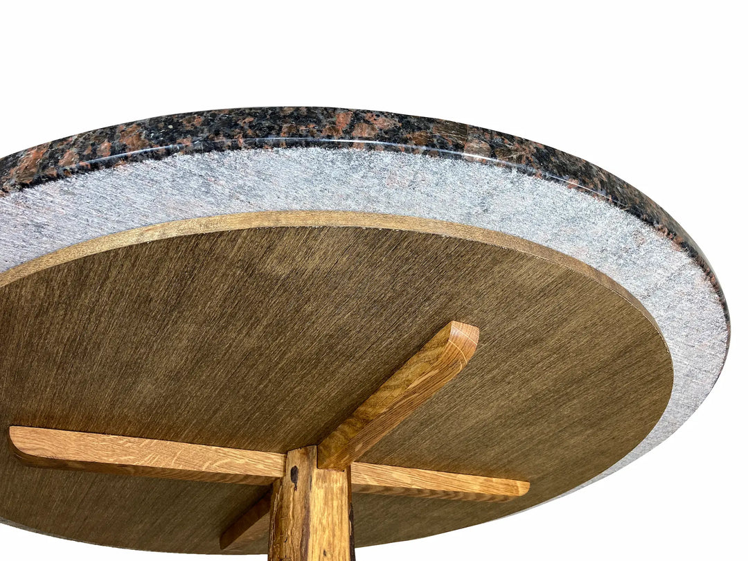 The underside support of a round granite top table made of birchwood plywood and oak under supports.