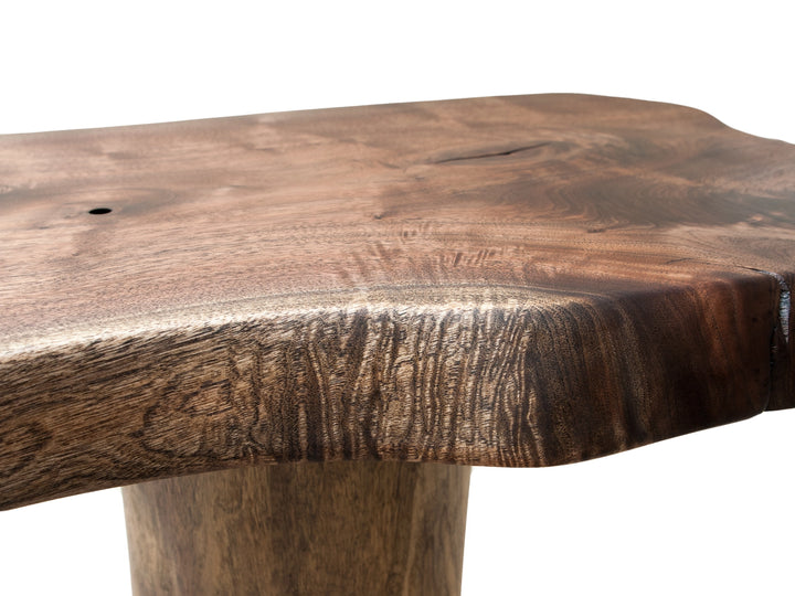 Close up of the fiddle back figuring of a live edge slab on a Black Walnut tree base against a white back drop.