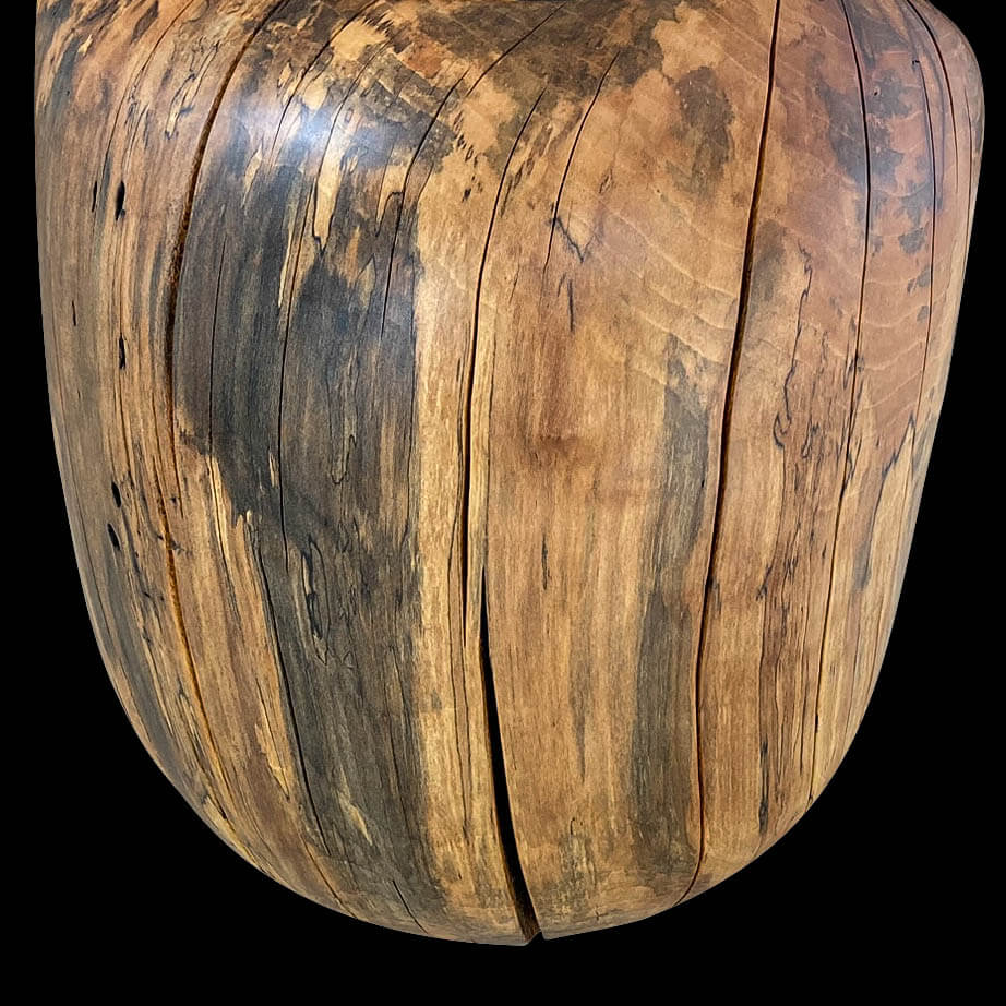 Close-up of back side of solid sycamore chair showing grain patters and natural oil finish.  Black background.