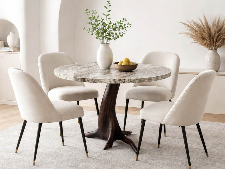 Dining room with a round granite top table  with a smooth dark black walnut tree base and four chairs in a bright, minimalistic setting.