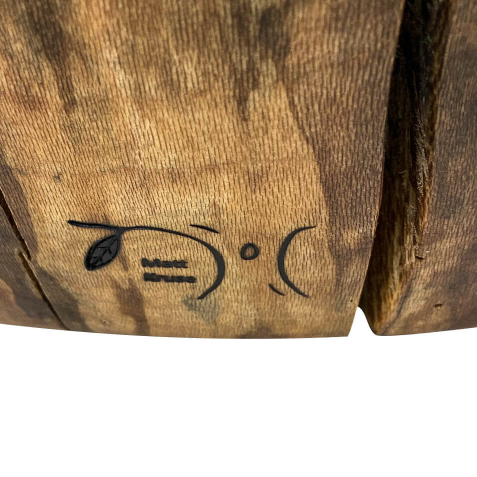 Base of chair with a heat brand of Ingrained Elegance.  A tree and leaf with name of artisan beneath.  White background.