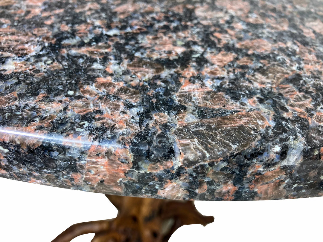 Super close up view of a Blue Dunes granite table top of mottled orange, black, white patterns.