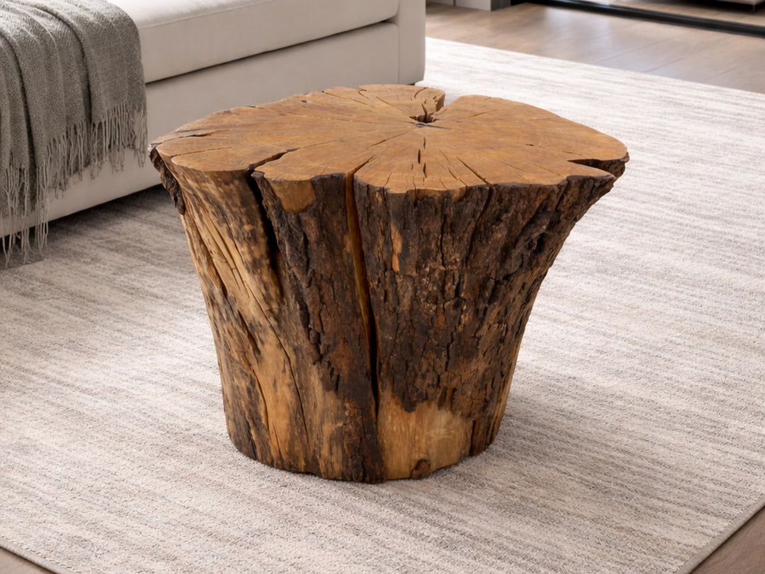 Staged view of a Sourwood coffee table made from tree stump resting on a rug near a sofa.