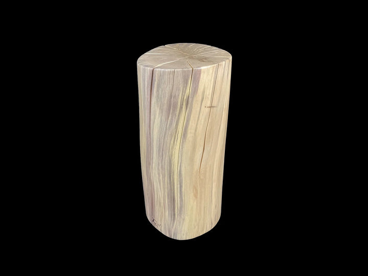 A cylindrical wooden side table made from a natural wood log section, featuring prominent grain patterns in light beige and brown tones, set against a solid black background.
