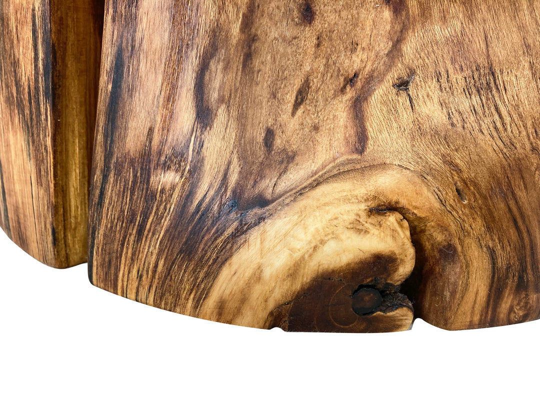 Close-up of a natural wood surface with rich grain, knots, and warm brown tones against a white background.
