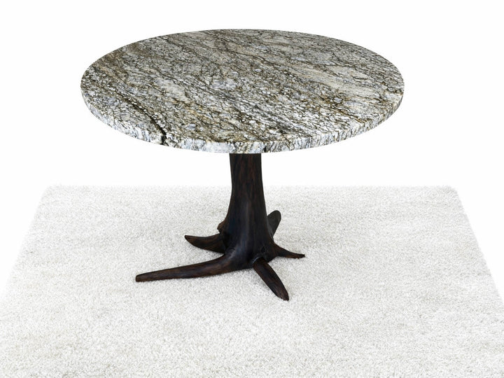 Top view of round granite top dining table on a dark walnut tree base