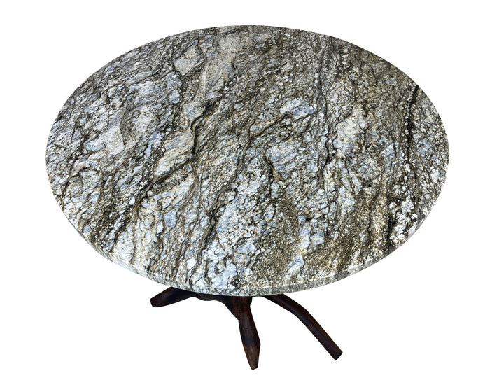 Beautiful round granite dining table with veins of green blue and white quartz running throughout