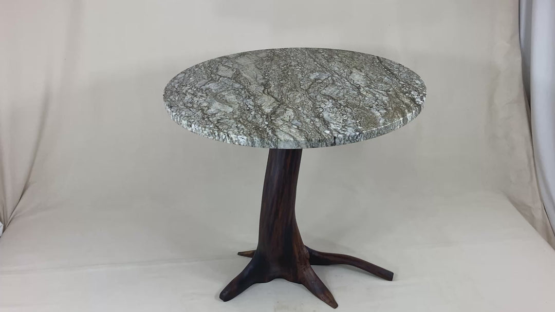 A Black Walnut tree base with a blue dunes granite top on a white back drop.