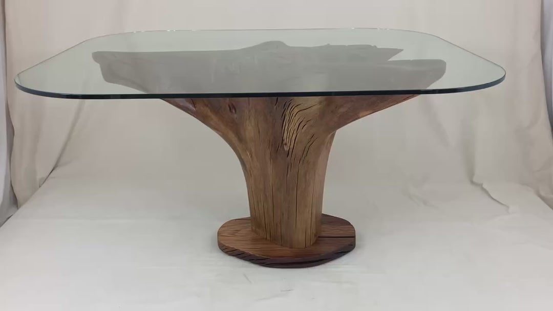 video of oak tree stump dining table with a glass top.